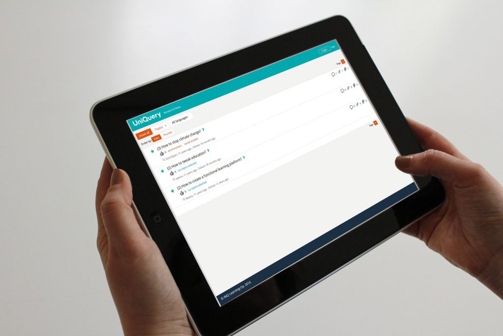 A learner holding a tablet displaying the UniQuery learning platform